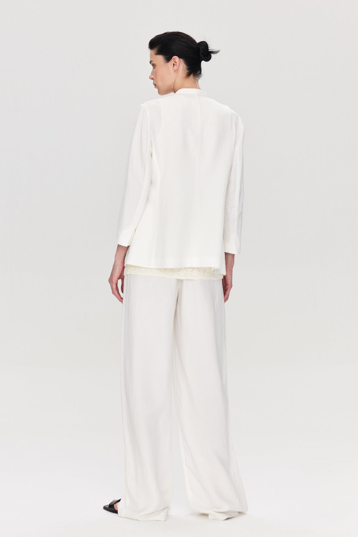 Person wearing a white outfit on a plain background